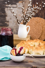Still life with pieces of monkey bread and berries jam on a wooden table. Rustic style