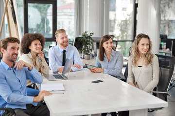 Small group of business people sitting at table and having meeting. Multi cultural group.