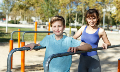 Family exercising on parallel bars outdoors