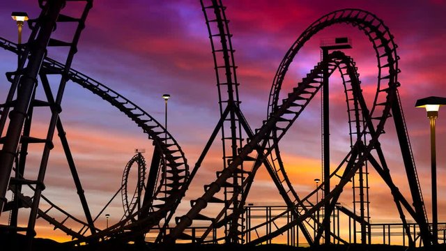 Roller coaster thrill ride at amusement park at sunset - 3d animation.