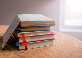 books sitting on table with lens flare effect. good for high school college and university students seeking knowledge and creative concepts. 