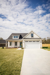 Obraz premium Modern new Construction White Siding Cottage House for Sale in Suburbs with Turquoise Door