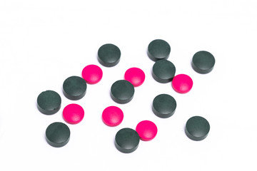 green and pink pills on white background