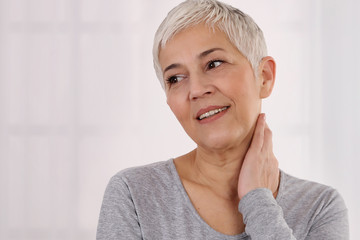 Senior Woman thyroid gland control. Health care and medical concept. Close up of female neck and shoulders.