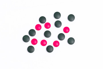 green and pink pills on white background
