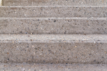 Three steps of a grey concrete staircase taken from the front