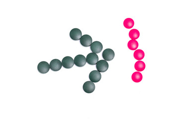 green and pink pills on white background