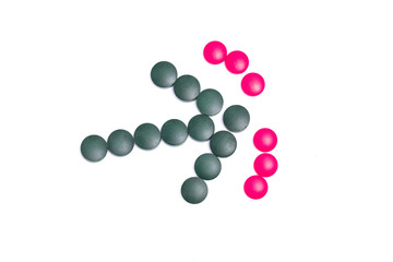 green and pink pills on white background