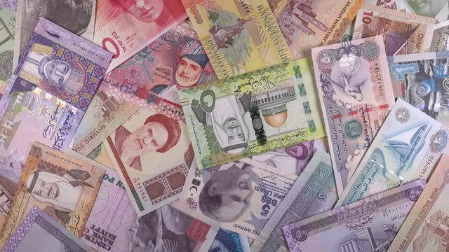 Heap of different Middle East banknotes slow rotating. Money currency background. 4K stock video footage