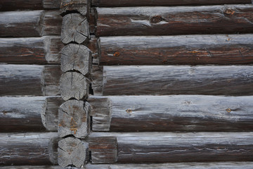 Old wooden wall of blockhouse. Facade of a log house built at the end of 19th century without nails in Russia.