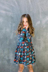 Small girl child model in beautiful dress. Childhood, look, happiness, hairstyle. Kid fashion, hairdresser, birthday. Little girl with long hair on grey background.