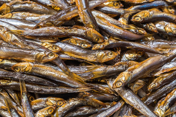 Cold smoked capelin fish background, smoked fish texture