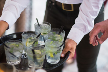 Mojito healthy ice cube Cocktail drink with burning cinnamon and lime, mint beverage on a bar counter. Selective focus. Top view. Trendy stylish edit. Copy paste space design service barman waiter