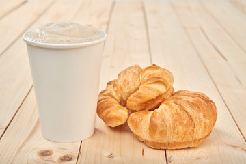coffee with croissnt on a wooden table