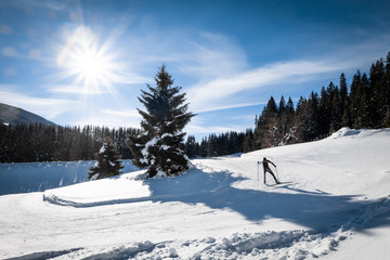 Fototapeta na wymiar Adult man running cross-country skiing in snow-covered holiday resort Hohentauern