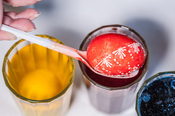 The process of painting eggs with food coloring and melted wax. Close up, soft focus. Homemade. Double painting. Preparing for the holiday Easter.