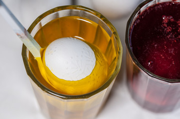Preparing for the holiday Easter. The process of painting eggs with food coloring and melted wax. Close up, soft focus. Homemade.