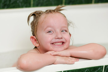 the child bathing in a bath with foam