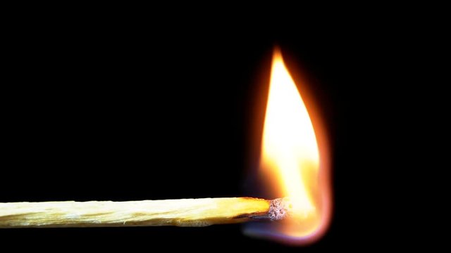 Igniting Match and Flame on a Black Background. Slow Motion