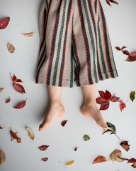 Kleine Füße inmitten von Herbtslaub