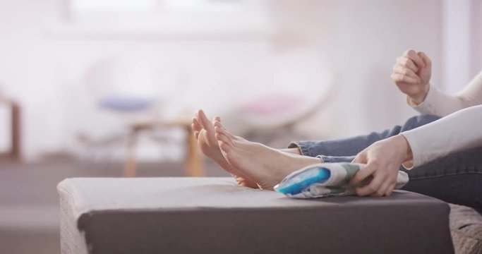 Young woman has joint pain and is chilling her feets