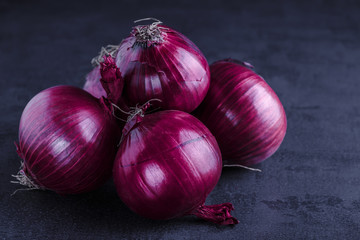 Red onions on a black table