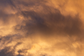 Storm clouds during sunset dyed golden colors. Climate change concept.