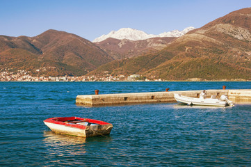 Fototapeta na wymiar Mediterranean landscape on sunny winter day. Montenegro, Adriatic Sea, Bay of Kotor. View of snow-capped mountain of Orjen