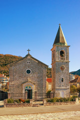 Fototapeta na wymiar Village church in Mediterranean. Montenegro, Tivat. View of Catholic Church of Saint Roch in Donja Lastva village on sunny winter day