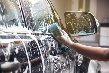 Man hands to catch the sponge and polish the car window. Concept car wash.