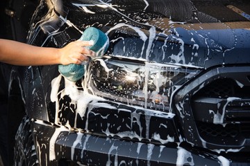 Man hands to catch the sponge and polish the car window. Concept car wash.
