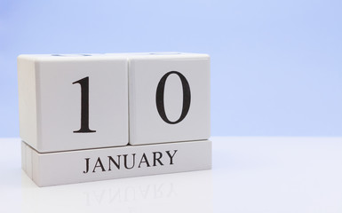 January 10st. Day 10 of month, daily calendar on white table with reflection, with light blue background. Winter time, empty space for text