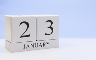 January 23st. Day 23 of month, daily calendar on white table with reflection, with light blue background. Winter time, empty space for text