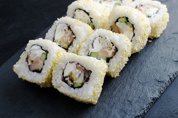 Sushi rolls sprinkled with sesame seeds. Fresh japanese rolls with eel and salmon.