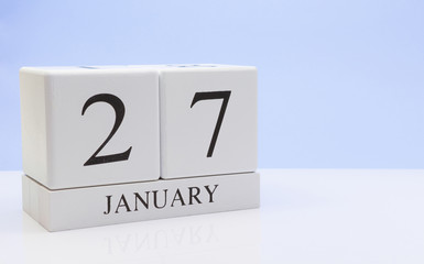 January 27st. Day 27 of month, daily calendar on white table with reflection, with light blue background. Winter time, empty space for text