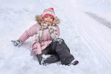 Fototapeta na wymiar A little happy girl in the snow.