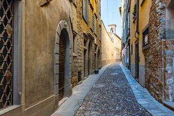 Fototapeta na wymiar Beautiful Old narrow street of small medieval city Citta Alta, perspective of street in Bergamo, Italy