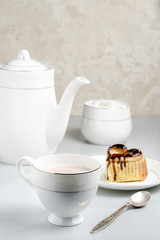 A heart-shaped cupcake decorated wiht chocolate. A cup of cocoa.