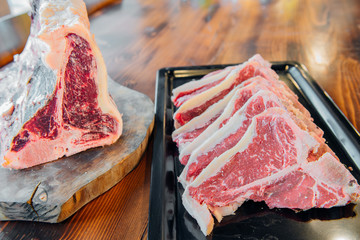 Raw and fresh t bone steak meats on wooden table in porterhouse.