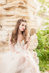 Portrait of a young bride in white lace boudoir with wavy dark hair