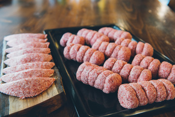 Raw and fresh meatballs on wooden table in restaurant