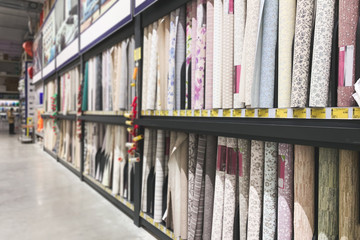 Many different colored wallpapers in the supermarket showcase. Choice of wallpapers in a warehouse. Background. Copyspace. Department of wallpaper in the supermarket