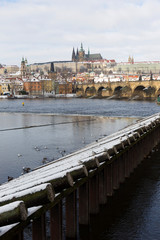 Fototapeta premium Snowy Prague Lesser Town with Prague Castle and Charles Bridge, Czech republic