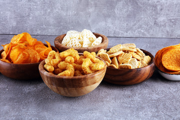 Salty snacks. Pretzels, chips, crackers in wooden bowls.