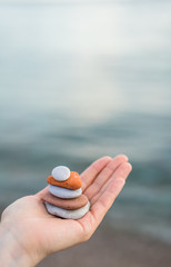 Pile of stacked stones in human hand