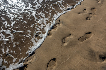 Orme sulla sabbia in riva al mare