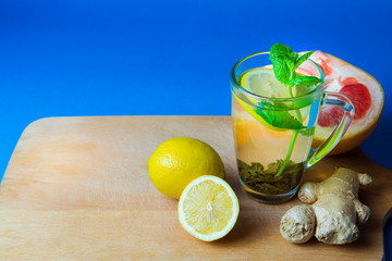 Green tea with lemon, ginger, grapefruit, mint. Blue background