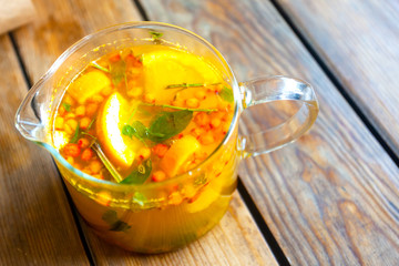 glass teapot with orange sea buckthorn fruit tea