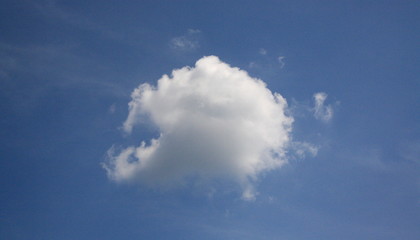 single cloud against a deep blue sky with copy space