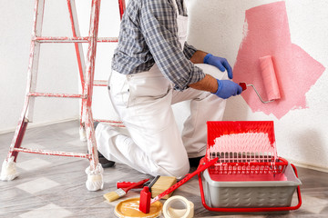 Professional house painter at work painting the wall © francescomou
